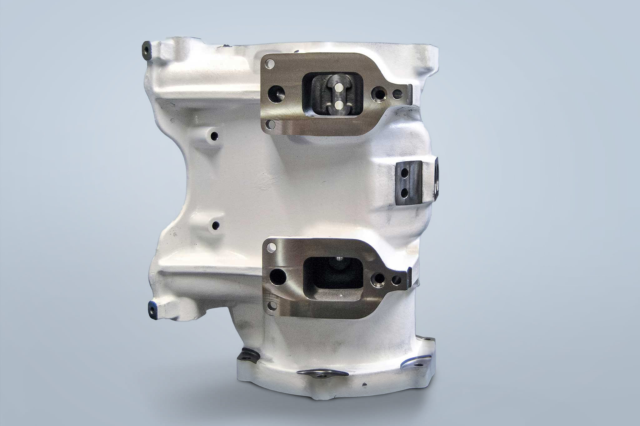 Against a white background, an exhaust duct housing made of grey cast iron is shown.