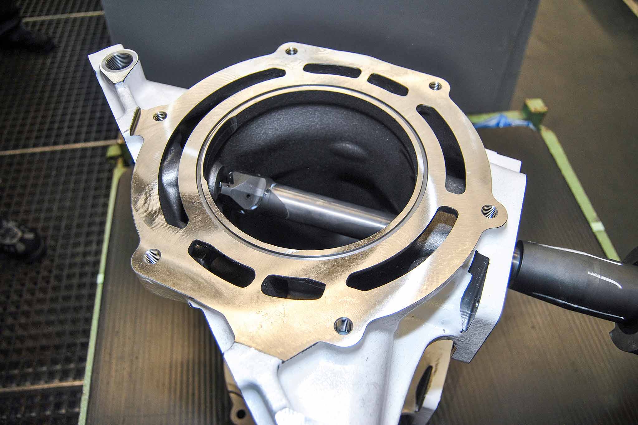 View through a large opening into the part. The milling cutter is retracted into the part and at its point of action.