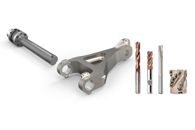 Das Bild zeigt das Musterteil eines Torsionsgelenks und verschiedene Werkzeuge, mit denen dieses bearbeitet werden kann.  