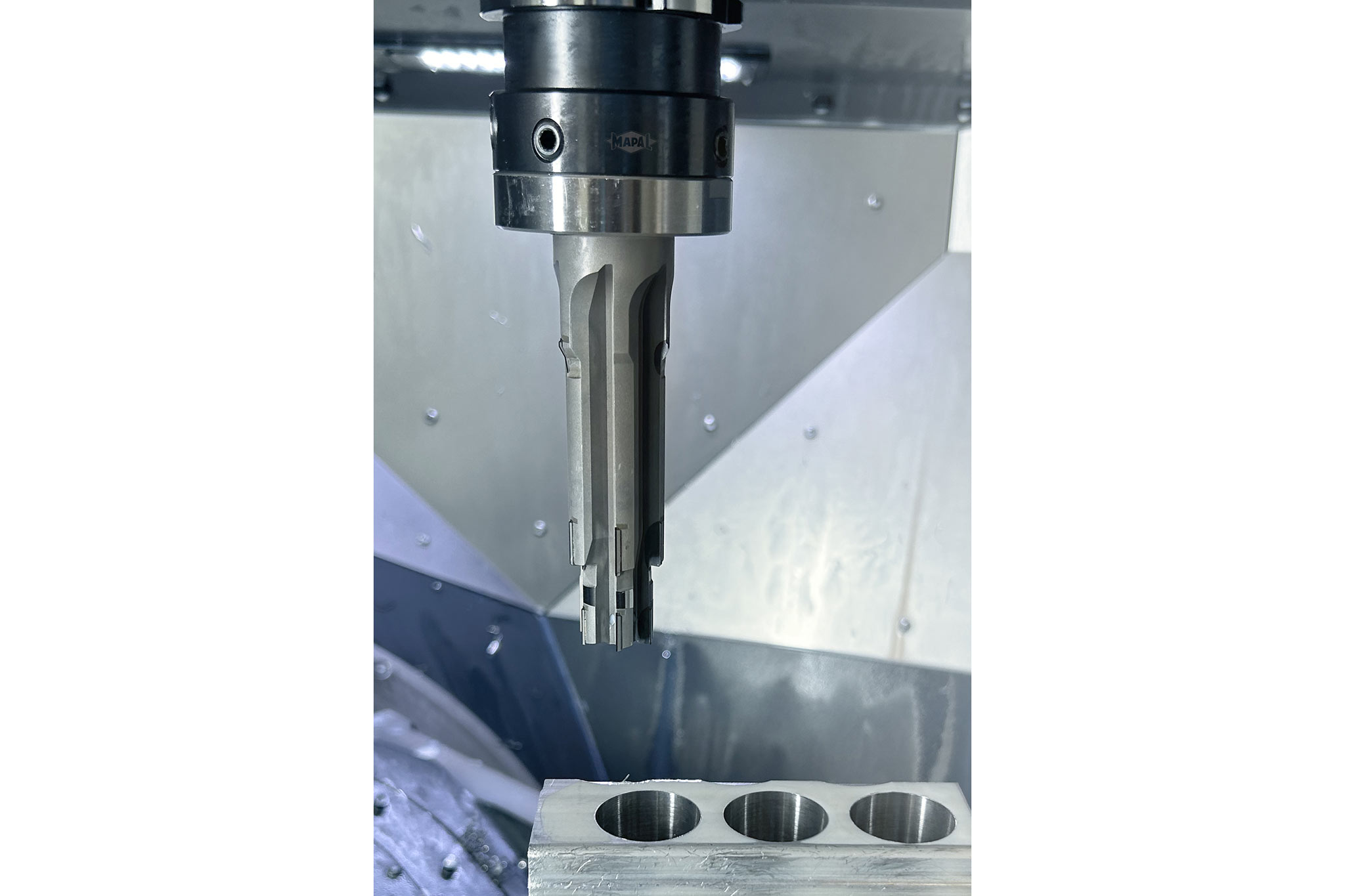 Ein Stufenwerkzeug von MAPAL ist eingespannt in einer Werkzeugmaschine bei der Bearbeitung eines Aluminiumbauteils zu sehen.