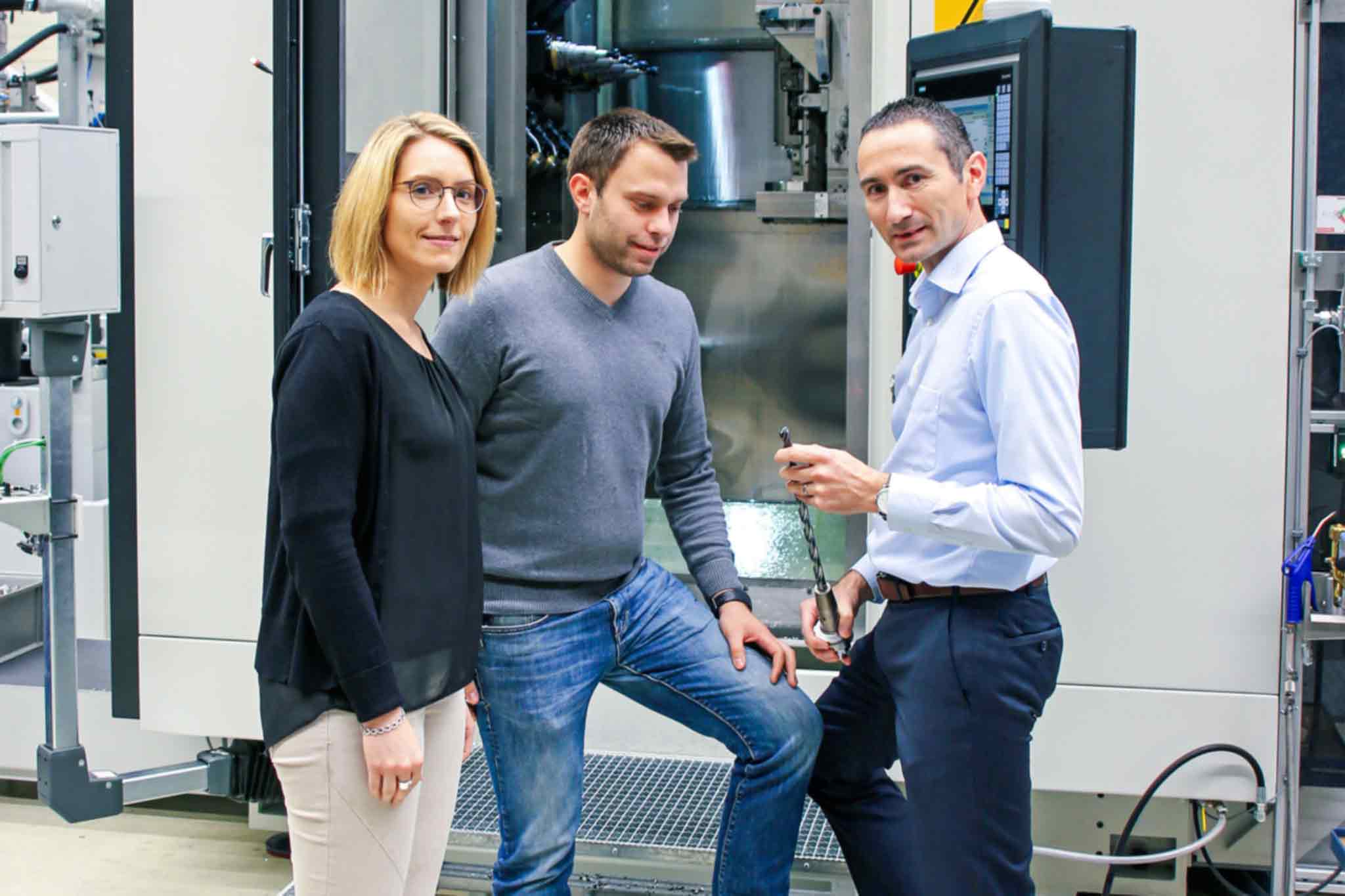 Carina Becker (l.) und Jörg Rodehutskors (Mitte) im Gespräch mit Alexander Wiesner vor einem Fertigungsmodul FM3+X hd.
