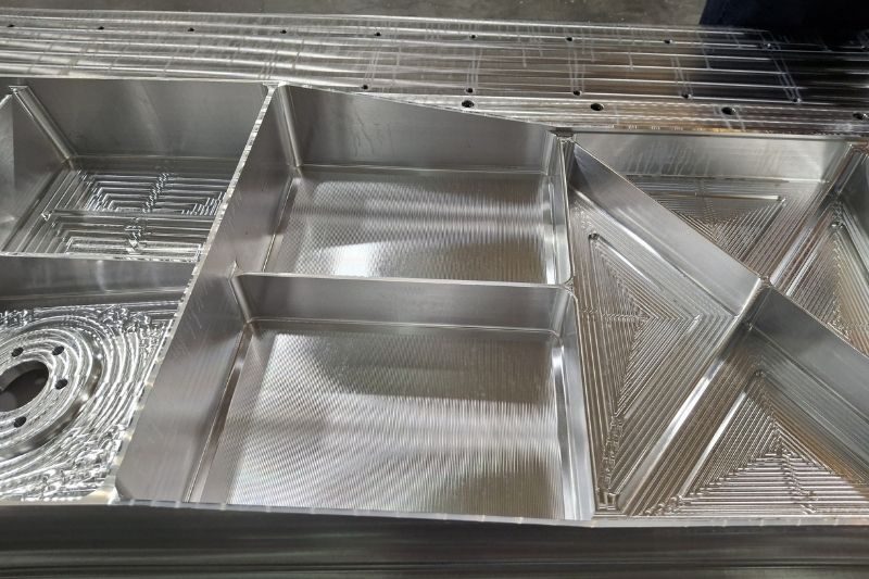 Das Bild zeigt das Aluminium-Musterbauteil mit den bis zu 125 mm tiefen, gefrästen Taschen.