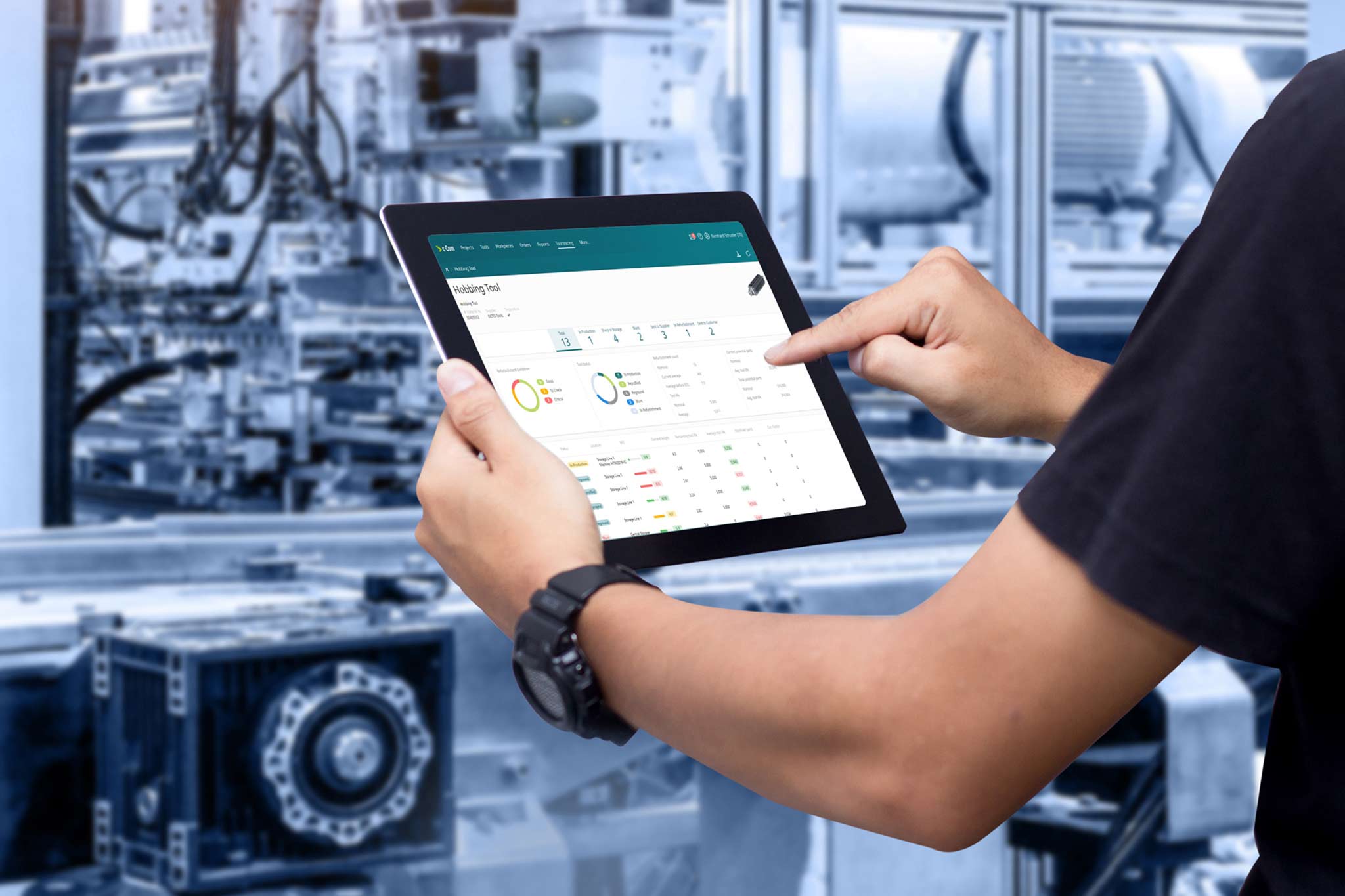 A man stands in the production environment and follows the digital twin of a hobbing tool on a tablet.