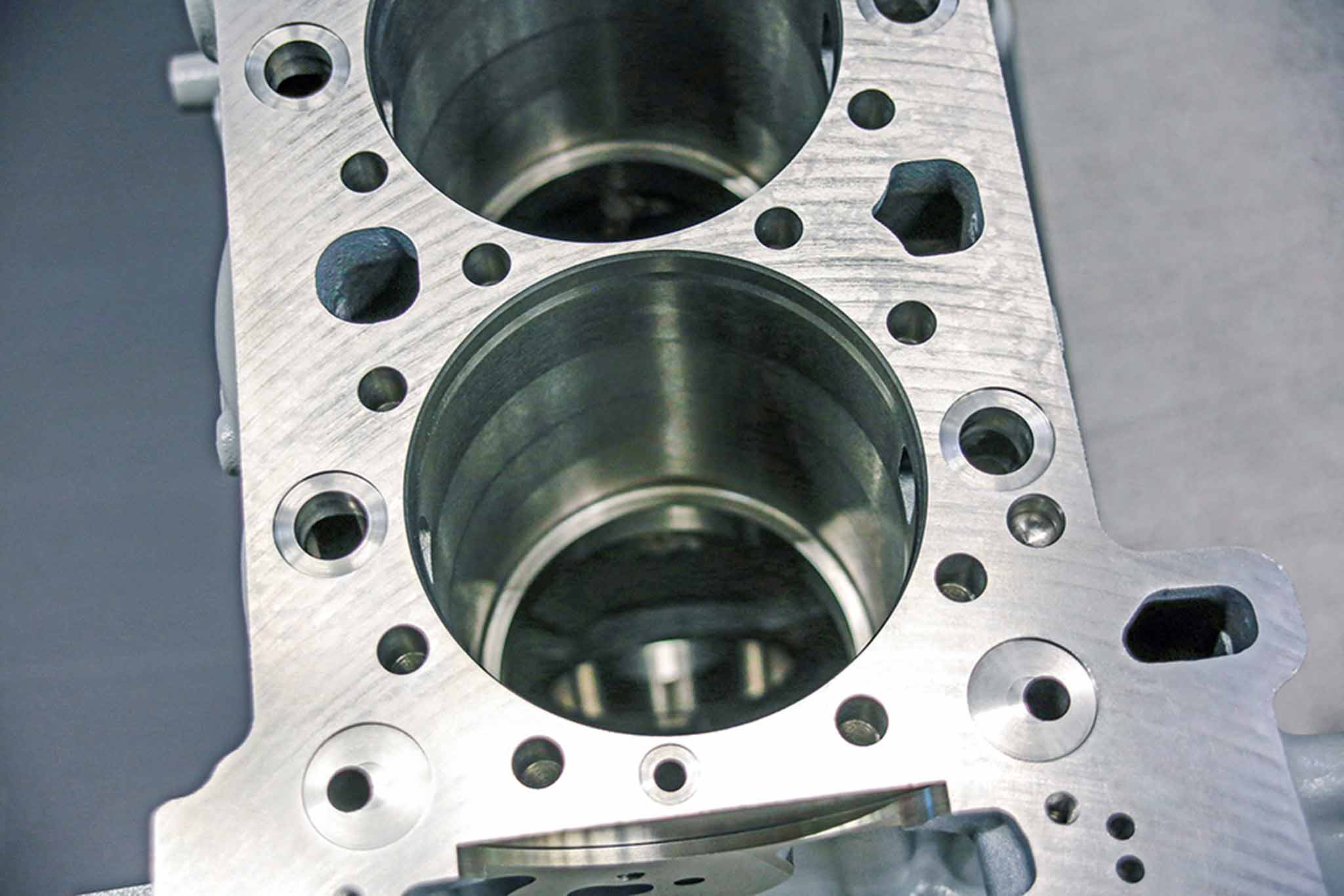 Ausschnitt eines LKW-Motorblocks. Von oben sind die Aufnahmen für Zylinderlaufbuchsen zu sehen.
