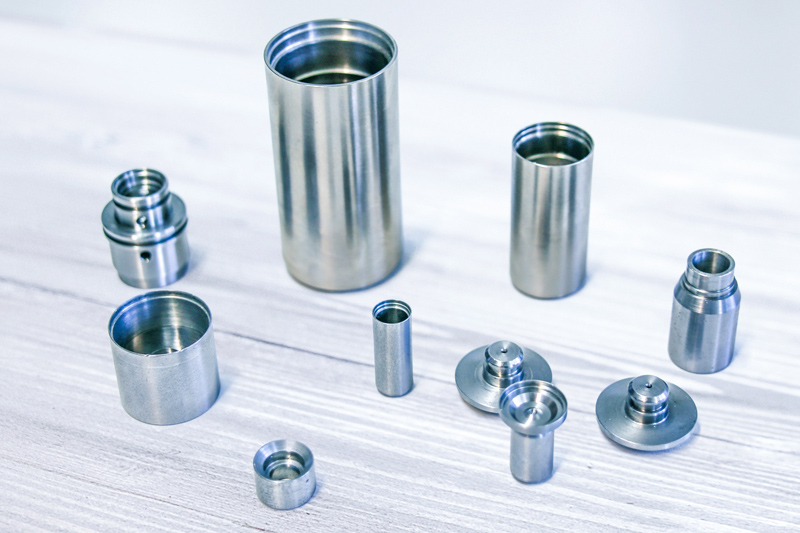 A selection of turned parts is arranged on a table.